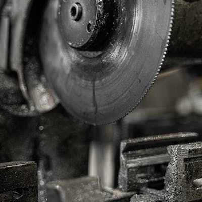 Detailed view of a circular saw blade in a factory setting, showcasing sharp precision.